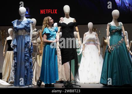 Un assistente della galleria regola una riproduzione dell'abito di vendetta della principessa Diana, che fa parte della collezione di oltre 450 costumi, set e oggetti di scena della serie Netflix The Crown, in mostra a Bonhams nel centro di Londra, prima di essere messo all'asta il mese prossimo. Data immagine: Martedì 9 gennaio 2024. Foto Stock