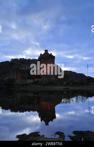 Vista al tramonto sul castello di Eilean Donan, sul villaggio di Dornie, su Kyle of Lochalsh, Wester Ross, Scozia, REGNO UNITO Foto Stock