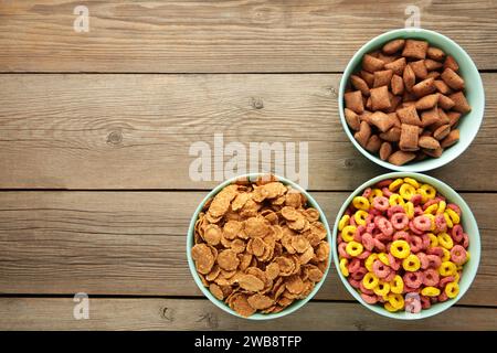Varietà di cereali in ciotole blu, colazione veloce su sfondo di legno grigio. Vista dall'alto Foto Stock
