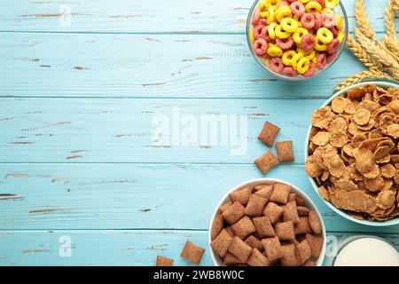Varietà di cereali in ciotole blu, colazione veloce su sfondo di legno blu. Foto verticale Foto Stock