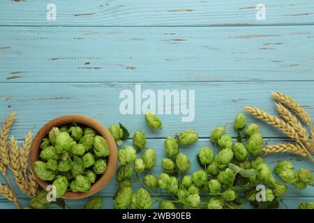 Luppolo e grano dorato maturo di cono su un vecchio tavolo blu. Vista dall'alto Foto Stock