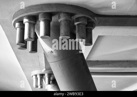 Un primo piano di viti metalliche fissate sul lato inferiore di una struttura a ponte Foto Stock