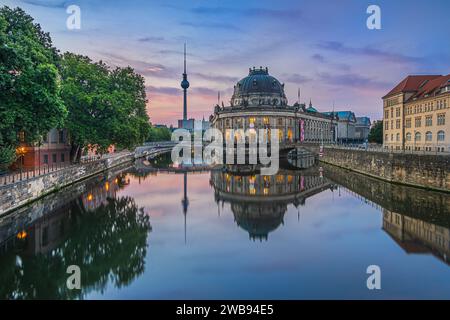 Skyline di Berlino al mattino all'alba. Museum Island con edifici storici illuminati e torre della televisione. River Spree con riflessi. Foto Stock