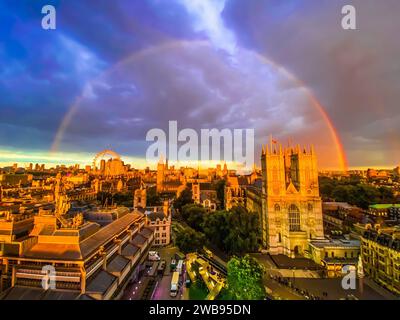Uno splendido paesaggio urbano è illuminato da un magnifico arco arcobaleno che attraversa il cielo Foto Stock