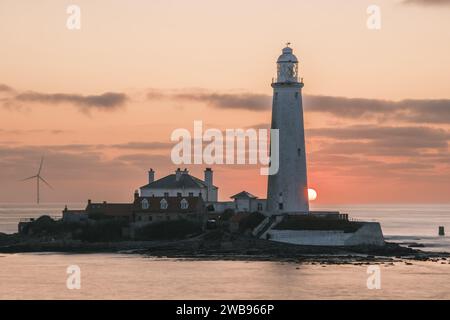 Alba al faro di St. Marys a lato del fiume con il sole estivo che sorge alle spalle. Foto Stock