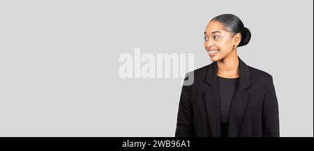 Profilo laterale di una donna d'affari afroamericana in posa con un sorriso travolgente Foto Stock