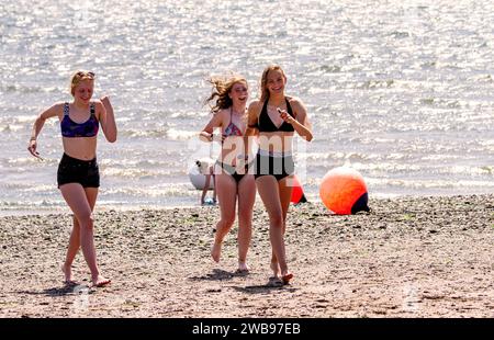 Durante il caldo clima estivo, le giovani donne si divertono lungo la spiaggia di Broughty Ferry a Dundee, in Scozia, nel Regno Unito Foto Stock