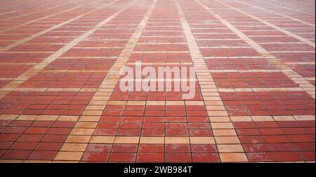 Pavimento in mattoni rossi ordinato su uno sfondo a motivi. Foto Stock