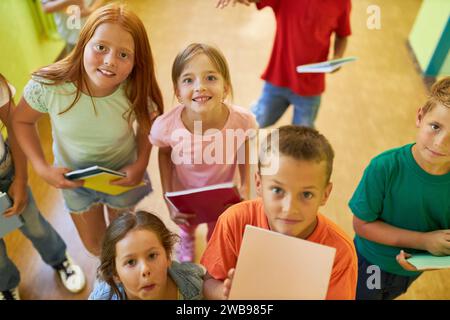 Vista ad alto angolo di studenti sorridenti in piedi insieme nel corridoio della scuola Foto Stock