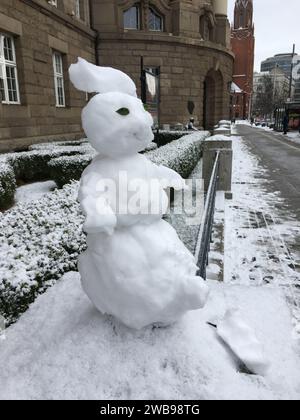 Un piccolo pupazzo di neve è migliorato su un palo di pietra. Versione mini. Inverno in Polonia. Foto Stock