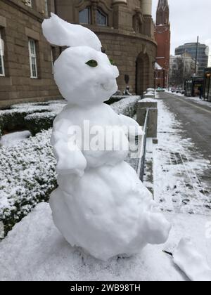 Un piccolo pupazzo di neve è migliorato su un palo di pietra. Versione mini. Inverno in Polonia. Foto Stock