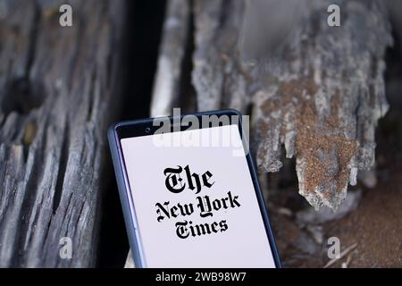 Dhaka, Bangladesh - 9 gennaio 2024: Mani che tengono uno smartphone con il logo del New York Times sullo schermo. Il New York Times è un giornale americano. Foto Stock