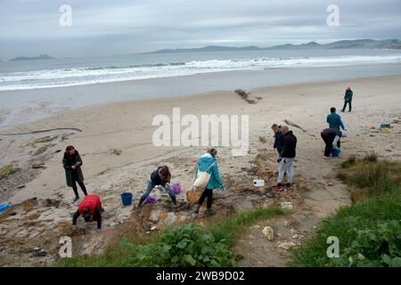 Numerosi volontari si sono recati sulle spiagge della Galizia per raccogliere pellet di plastica caduti su una barca utilizzando strumenti di base come imbuti, filtri, Foto Stock