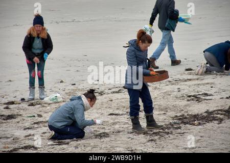 Numerosi volontari si sono recati sulle spiagge della Galizia per raccogliere pellet di plastica caduti su una barca utilizzando strumenti di base come imbuti, filtri, Foto Stock