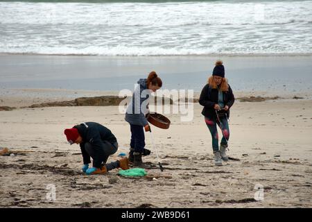 Numerosi volontari si sono recati sulle spiagge della Galizia per raccogliere pellet di plastica caduti su una barca utilizzando strumenti di base come imbuti, filtri, Foto Stock