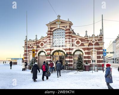 I clienti che entrano nella vecchia sala del mercato di Helsinki, Finlandia, in inverno Foto Stock