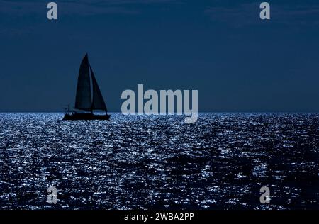 Catamarano a vela in una notte al chiaro di luna. Nelle banche di Bahama Foto Stock