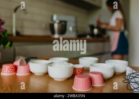 Ampia scelta di rivestimenti per cupcake in diversi colori con teglia per muffin e frusta metallica. Foto Stock