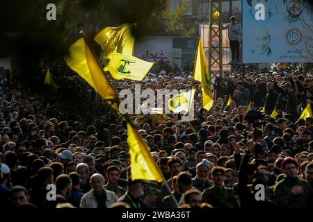 Khirbet SELM, Libano. 9 gennaio 2024. I sostenitori pro-iraniani di Hezbollah portano la bara del comandante supremo del partito Wissam Tawail durante la sua processione funebre nel villaggio libanese meridionale di Khirbit Selem. Tawil è il comandante di Hezbollah di grado più alto ad essere ucciso dopo l'eruzione del conflitto transfrontaliero tra Israele e Hezbollah in Libano l'8 ottobre, e il secondo assassinio di alto profilo avvenuto in Libano in due settimane. Crediti: Marwan Naamani/dpa/Alamy Live News Foto Stock