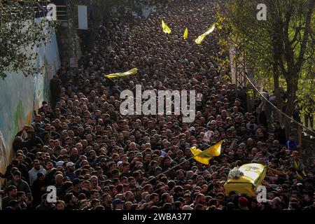 Khirbet SELM, Libano. 9 gennaio 2024. I sostenitori pro-iraniani di Hezbollah portano la bara del comandante supremo del partito Wissam Tawail durante la sua processione funebre nel villaggio libanese meridionale di Khirbit Selem. Tawil è il comandante di Hezbollah di grado più alto ad essere ucciso dopo l'eruzione del conflitto transfrontaliero tra Israele e Hezbollah in Libano l'8 ottobre, e il secondo assassinio di alto profilo avvenuto in Libano in due settimane. Crediti: Marwan Naamani/dpa/Alamy Live News Foto Stock