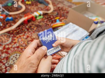 Parigi, Francia - 1 settembre 2023: Un bambino e un padre che esaminano un pacchetto di sapone tedesco Klar Seifen, del peso di 100 grammi, che ne dimostra la qualità e la semplicità Foto Stock