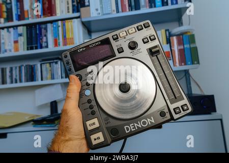 Parigi, Francia - 24 ottobre 2023: Primo piano di una modifica manuale delle impostazioni di un lettore CD Denon DJ contro una libreria Vitsoe Foto Stock