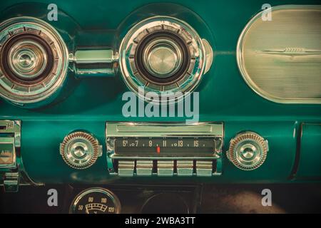 Immagine in stile retrò di una vecchia autoradio all'interno di una classica auto americana verde Foto Stock