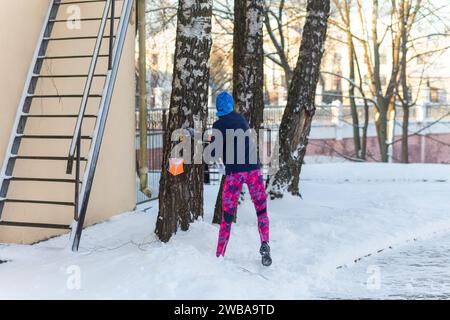 La giovane donna partecipa alla formazione di orientamento invernale in condizioni urbane. Attività del punto di controllo dell'orientamento all'esterno Foto Stock