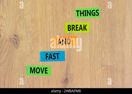 Muoviti in fretta e rompi il simbolo. Le parole concettuali si muovono velocemente e si rompono su carta colorata. Splendido sfondo in legno. Affari, muoviti in fretta e in libertà Foto Stock