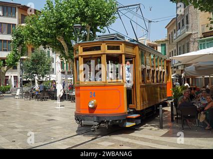 Il tram d'epoca attraversa la piazza del mercato di Soller, vicino a caffetterie e persone. Maiorca Spagna. Foto Stock