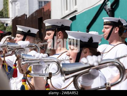 Giovani musicani della band che suonano trombe durante la parata dei tri-service durante la giornata delle forze armate a Falmouth in Cornovaglia Foto Stock