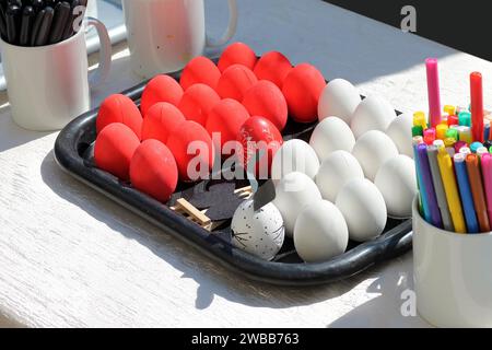 Uova di Pasqua dipinte in rosso e bianco per la creatività su un vassoio Foto Stock