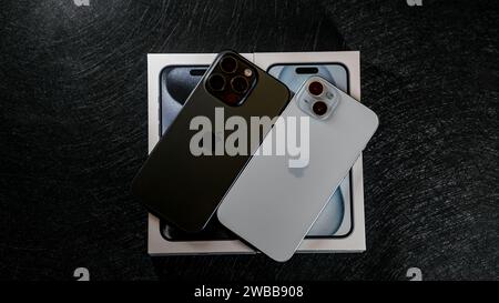 Jurmala, Lettonia - 09 01 2024: Su tavolo nero su scatola bianca con il nuovo iPhone 15 Blue Titanium e iPhone 15 Plus in colore blu su tavolo nero. Foto Stock