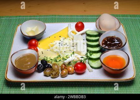 Tavolo per la colazione turco. Dolci, verdure, verdure, olive, formaggi, uova fritte, marmellate, miele, tè in pentola di rame e bicchieri tulipano, ampia composizione Foto Stock