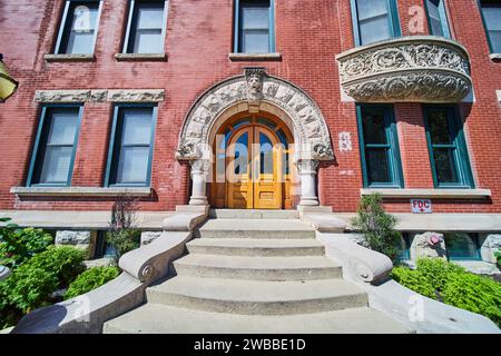 Elegante ingresso dell'edificio in mattoni rossi con arco e colonne Foto Stock