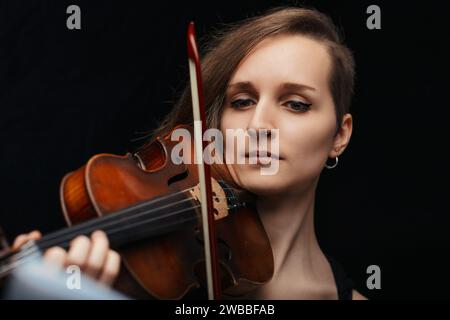 la violinista, immersa nella sua musica, crea un'atmosfera di solennità e concentrazione, una testimonianza della sua arte Foto Stock