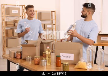 Confezionamento volontario di prodotti alimentari al tavolo del magazzino Foto Stock