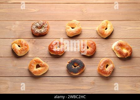 Gustosi bagel con semi di sesamo e papavero su sfondo di legno Foto Stock