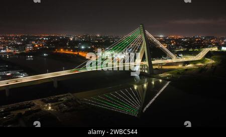 Abidjan. 10 gennaio 2024. Questa foto aerea scattata il 1° dicembre 2023 mostra una vista notturna del Cocody Bridge ad Abidjan, Costa d'Avorio. Il Cocody Bridge nella capitale economica della Costa d'Avorio, Abidjan, con una lunghezza totale di circa 1,63 chilometri, è costruito dalla China Road and Bridge Corporation. Come progetto volto a migliorare il sostentamento delle persone, il Cocody Bridge riduce efficacemente la congestione del traffico nel centro di Abidjan e fornisce supporto per l'aggiornamento e la ristrutturazione del traffico della città. Crediti: Xinhua/Alamy Live News Foto Stock