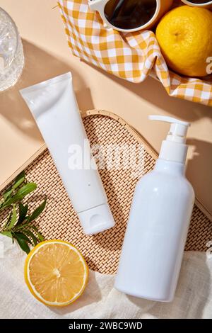 Scenario di mockup per la pubblicità e il branding di prodotti cosmetici di estratto di limone - tubo di plastica bianco e flacone a pompa senza marchio su sfondo beige con le Foto Stock