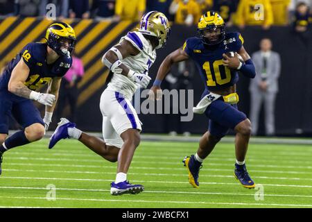 Il quarterback dei Michigan Wolverines Alex Orji (10) porta la palla mentre il cornerback dei Washington Huskies Dominique Hampton (7) chiude per il tackle durante Foto Stock