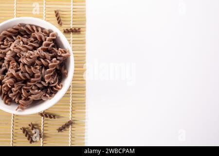 Fusilli di grano saraceno cotti biologici su fondo bianco. Tagliatelle integrali senza glutine. Concetto di cibo sano Foto Stock