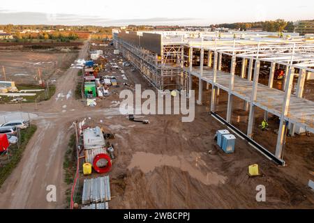 Fotografia con droni di cantieri di grandi edifici commerciali con macchinari edili e operai edili durante la soleggiata mattinata autunnale Foto Stock