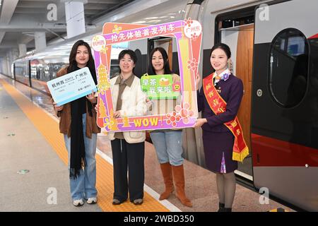 Hangzhou, provincia cinese di Zhejiang. 10 gennaio 2024. I passeggeri e i membri del personale posano per una foto di gruppo prima che un treno proiettile partisse per la stazione ferroviaria di Guangzhou Est nella provincia del Guangdong, nella Cina meridionale, alla piattaforma della stazione ferroviaria di Hangzhou Ovest a Hangzhou, nella provincia dello Zhejiang, nella Cina orientale, il 10 gennaio 2024. Un nuovo servizio ferroviario passeggeri che collega direttamente la stazione ferroviaria di Hangzhou Ovest a Hangzhou e la stazione ferroviaria di Guangzhou Est a Guangzhou è stato lanciato mercoledì. La Cina ha iniziato ad attuare un nuovo piano operativo ferroviario lo stesso giorno. Crediti: Huang Zongzhi/Xinhua/Alamy Live News Foto Stock