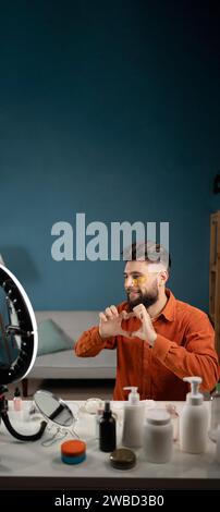 Uomo felice bellezza blogger in stile casual con un dito a forma di cuore, simbolo di amore, romanticismo. Blogger, influencer Guy che condivide le emozioni, fa come la mano Foto Stock