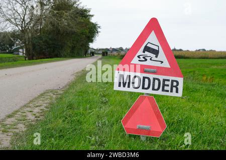 Segnale di avvertenza per fango o modder in olandese su strada in ambiente agricolo. Il fango arriva in strada dagli agricoltori durante il raccolto. Foto Stock