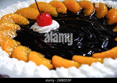 Torta di frutta al cioccolato con salsa di ciliegie e arance Foto Stock