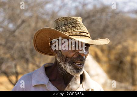 ritratto di un contadino afroamericano che indossa un cappello da cowboy, fuori nel campo in una giornata di sole Foto Stock