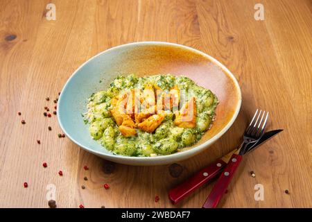 Gnocchi di patate con pollo fritto, gorgonzola, panna, mortadella, pistacchi, olio d'oliva, parmigiano e aglio Foto Stock