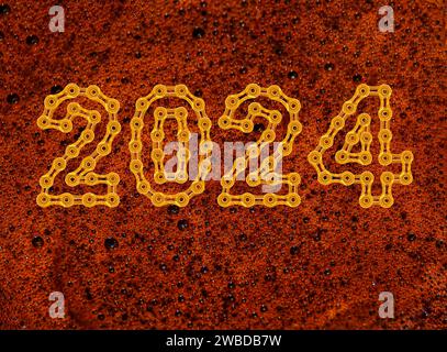 Tazza di caffè vista dall'alto con il felice anno nuovo 2024 realizzato con maglie a catena dorate Foto Stock